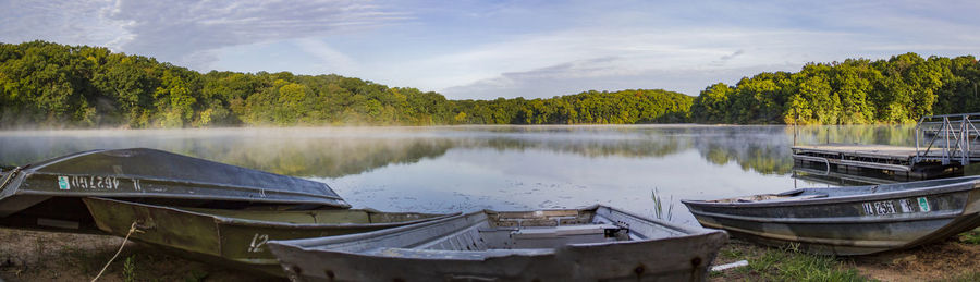 Panoramic view of boats moored in lake against sky