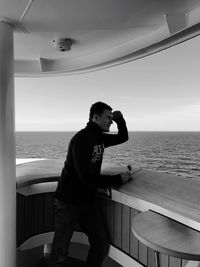 Man standing on boat while looking away against sky