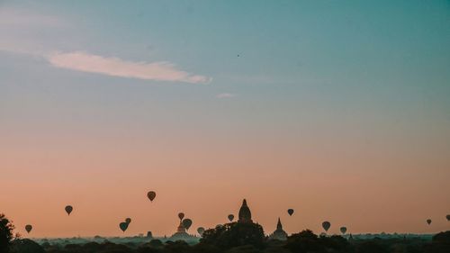 Silhouette of hot air balloons against sky during sunset