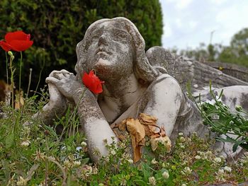 Statue amidst plants on field