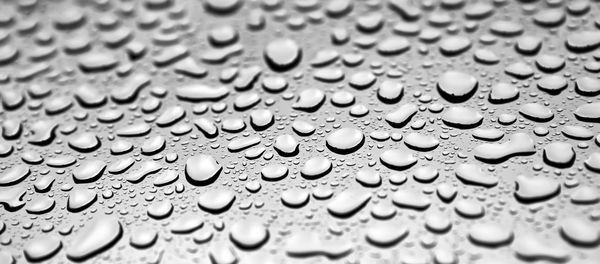 Full frame shot of raindrops on wet glass