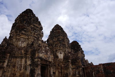 Low angle view of old temple against cloudy sky