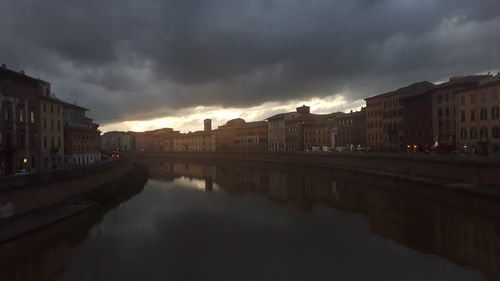 River amidst buildings against sky at dusk