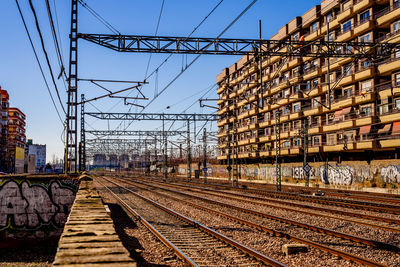 Railroad tracks by building against sky