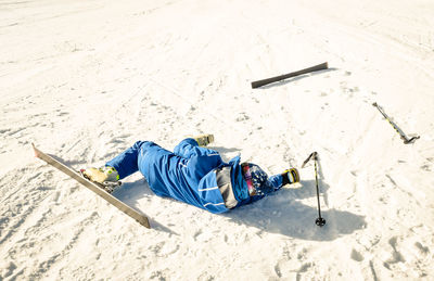 Man falling while skiing on snow