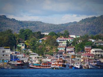 Scenic view of sea by townscape against sky