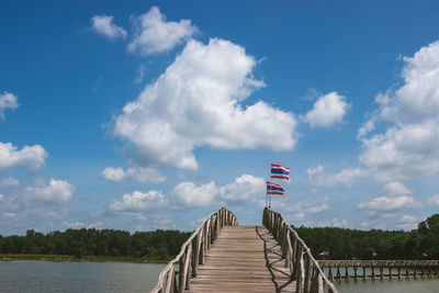 Scenic view of flag by lake against sky