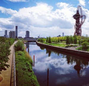 Scenic view of river by buildings against sky