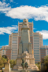 Low angle view of statue against buildings in city