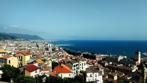 High angle view of townscape by sea against sky