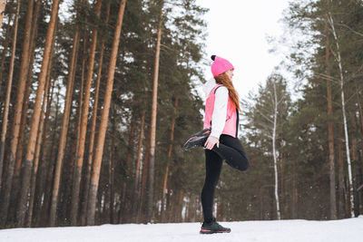 Full length of woman standing in forest