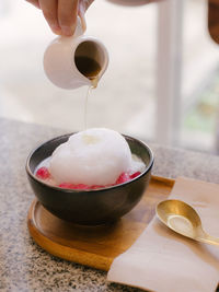 Midsection of person pouring coffee in cup