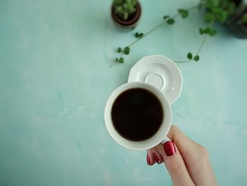 High angle view of hand holding coffee cup