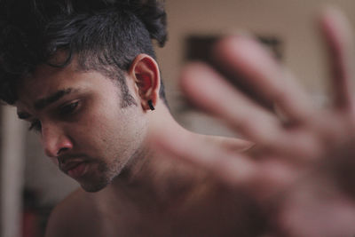 Close-up of shirtless young man looking down