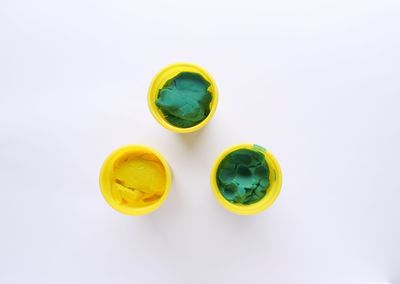 High angle view of yellow eggs against white background