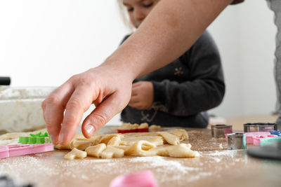 Father feeling playful with his caucasian little daughter, while preparing homemade dough l