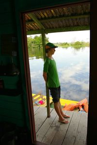 Full length of boy standing by window