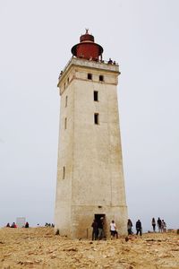 People on lighthouse against sky