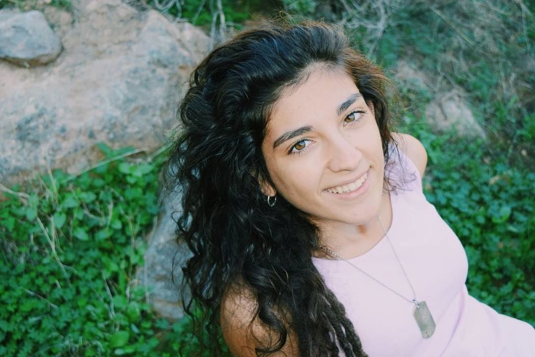 CLOSE-UP PORTRAIT OF SMILING YOUNG WOMAN AGAINST TREE