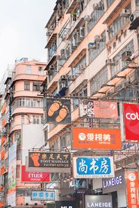 Low angle view of advertisements against buildings in city