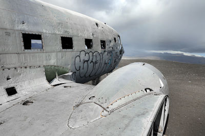 Abandoned airplane on airport runway against sky