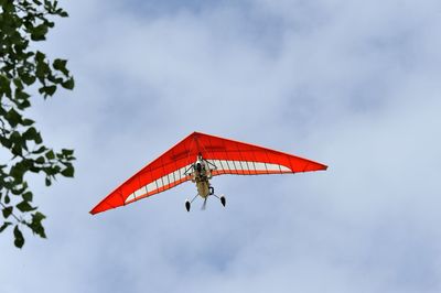 Low angle view of red flag flying against sky