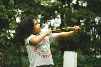 Girl standing against tree