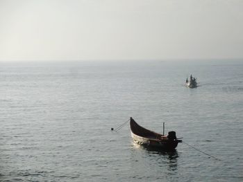 Boat sailing on sea against clear sky