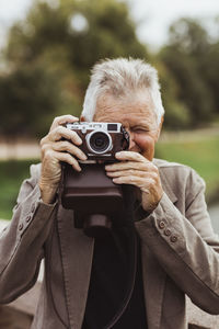 Senior man photographing with camera during weekend