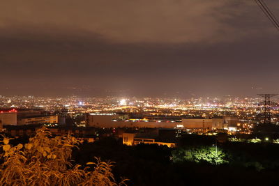 High angle view of illuminated buildings against sky at night