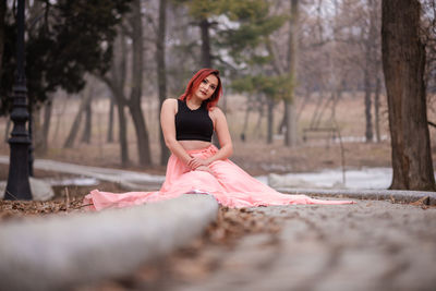 Portrait of young woman against trees