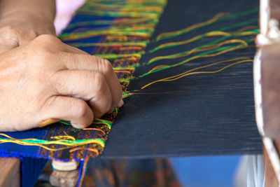 Cropped hand of woman weaving