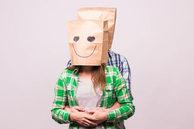 Portrait of a person hiding face against white background