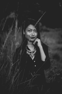 Portrait of beautiful young woman standing on field