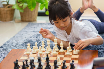 Full length portrait of girl playing on chess board