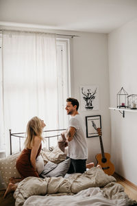 Woman sitting on bed at home