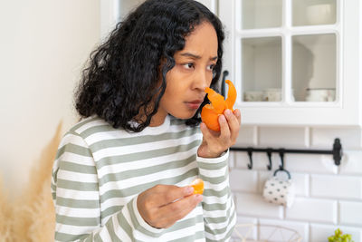 Young woman drinking juice in bathroom