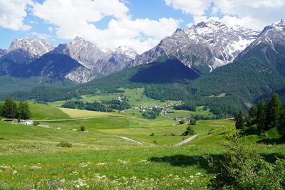 Scenic view of field and mountains against sky