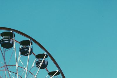 Low angle view of amusement park ride against blue sky