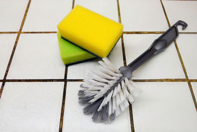 Close-up of brush and sponge scrub on flooring