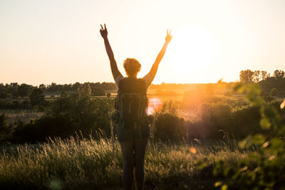 Rear view of silhouette woman standing on field against clear sky