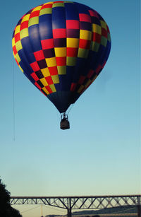 Low angle view of hot air balloons against clear blue sky