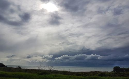 Scenic view of sea against storm clouds