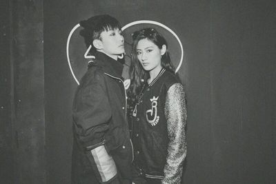 Portrait of young couple standing against wall