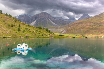 Lake of tignes surrounded by the peaks of the vanoise in haute tarentaise under a stormy sky