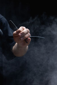 Cropped hand of man smoking cigarette