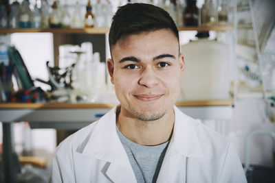 Portrait of confident young male chemistry student standing in college laboratory