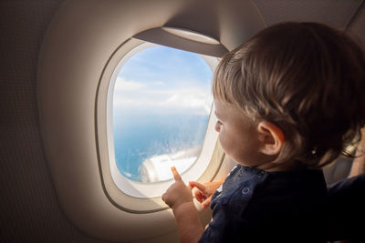 Girl looking through airplane window