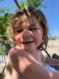 Close-up of smiling girl looking away while sitting outdoors