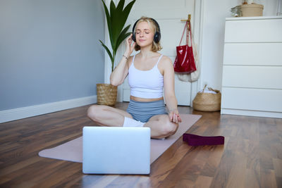 Side view of young woman sitting on table